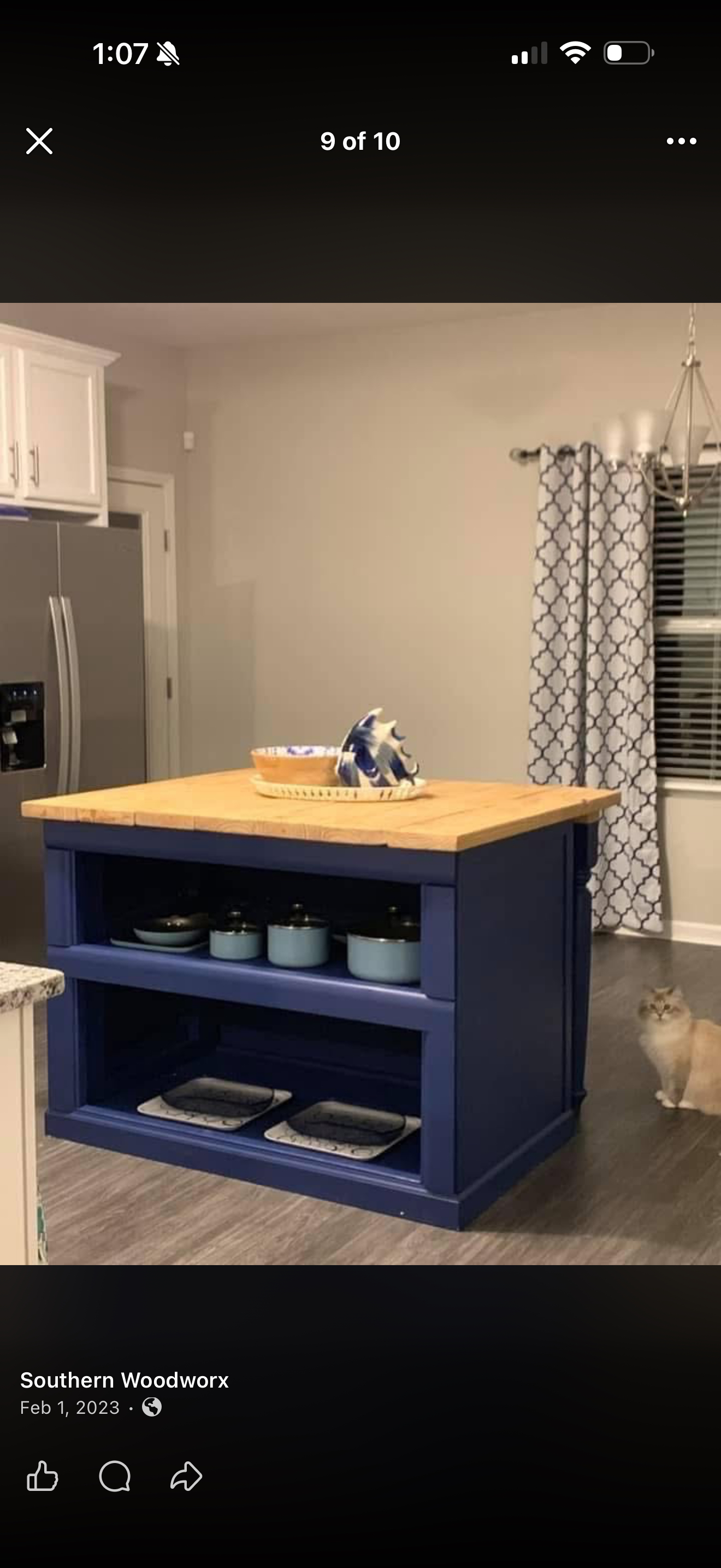 The navy kitchen island. A navy base with open storage and a contrasting wood top.