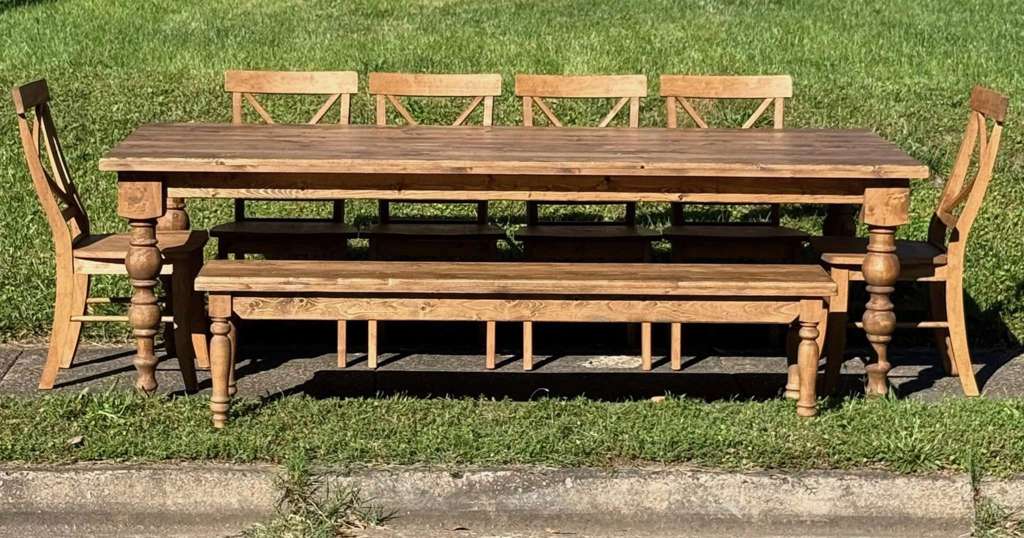Turned-leg dining set. A long wood dining table with a matching bench and X-back chairs.